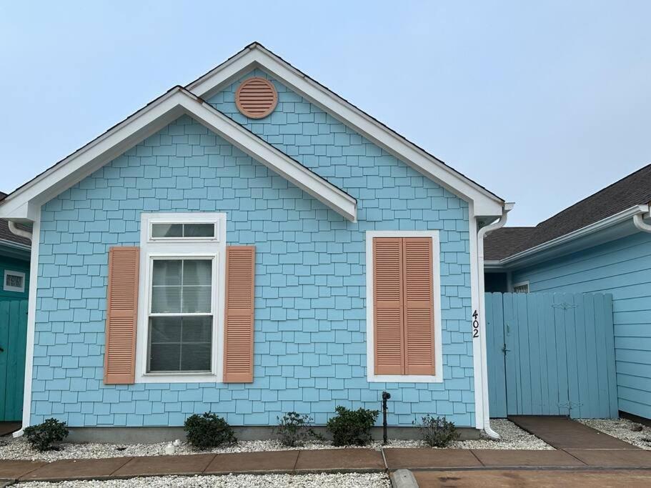 a blue house with a white window at Barefoot Bungalow - Pet Friendly- 2 Bdrm Townhome in Corpus Christi