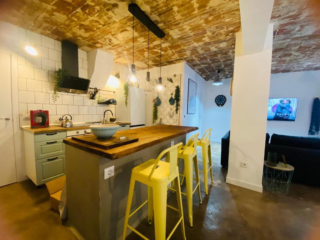 a kitchen with a counter and yellow stools in a room at ElenaHost City Park Center 5 in Madrid
