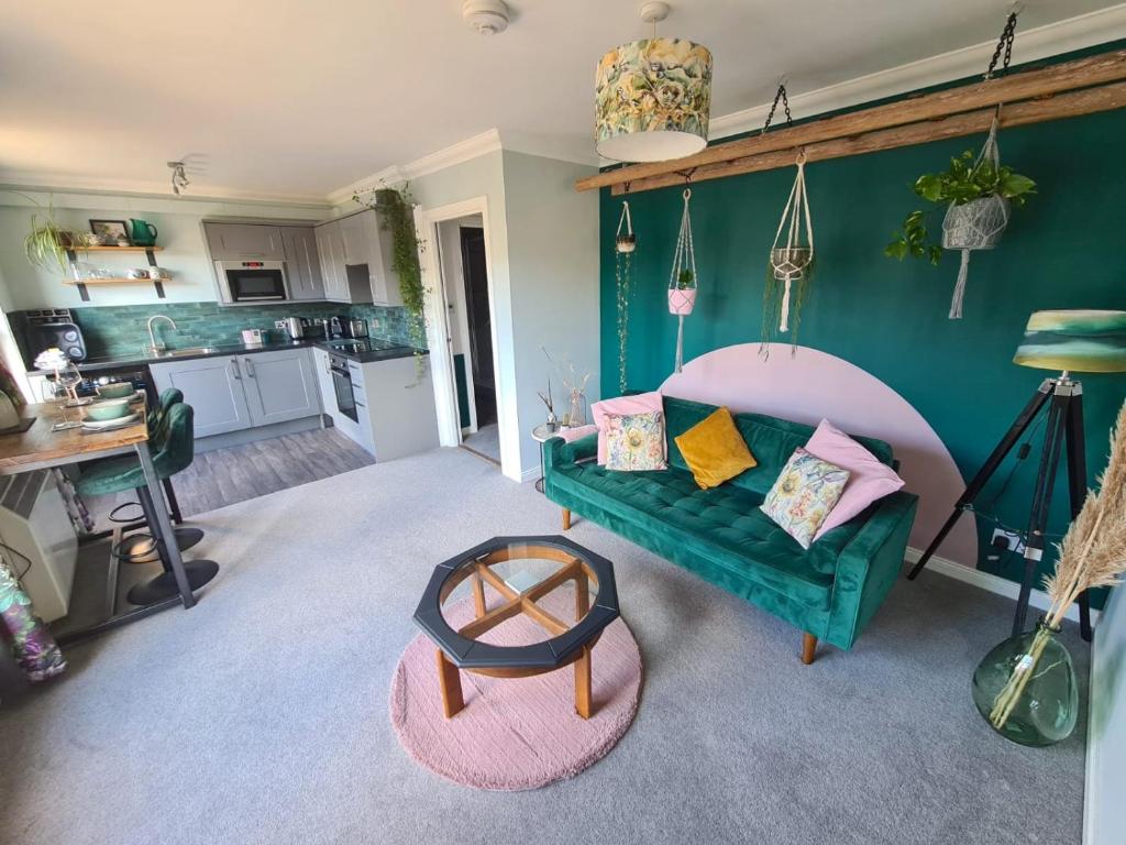 sala de estar con sofá verde y cocina en EDEN Apartment, Oban, en Oban