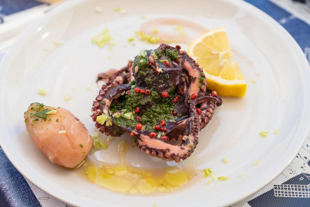 a plate of food with a shrimp and a lemon at Hotel Ferdinando Beach & Thermal Spa in Ischia