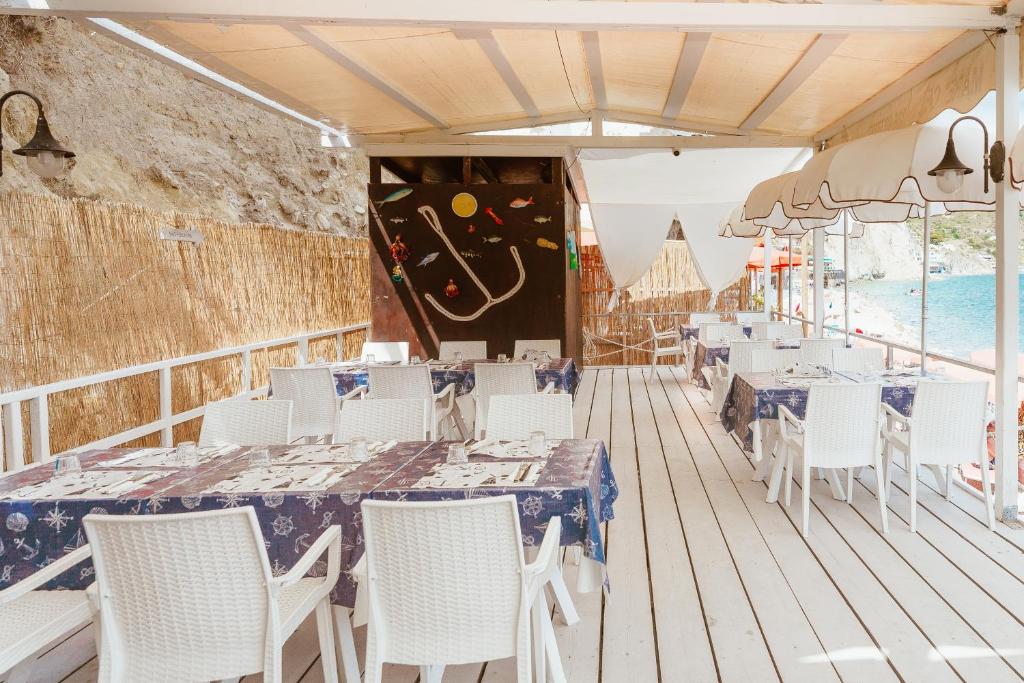 a restaurant with tables and chairs on a deck at Hotel Ferdinando Beach & Thermal Spa in Ischia