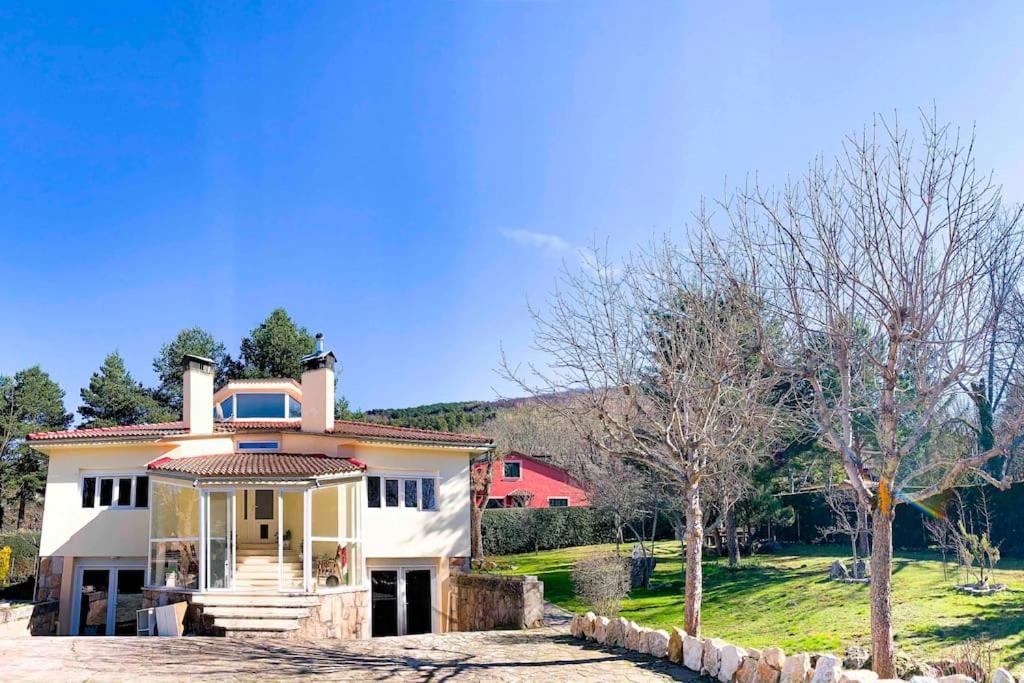 una gran casa blanca con una casa roja en Apartamento en Chalet La Rana Real, en La Granja de San Ildefonso