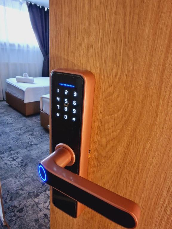 un mando a distancia que sale de una puerta de madera en Stay Inn Rediu en Iaşi