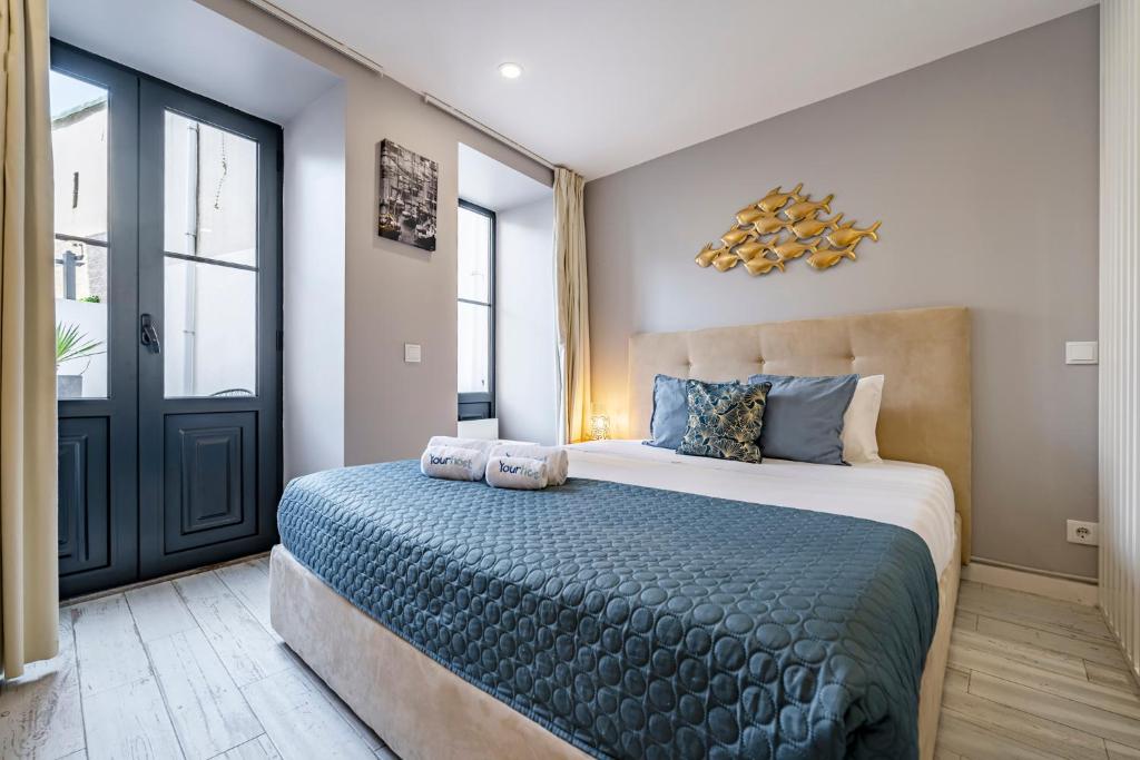 een slaapkamer met een groot bed en een groot raam bij Oporto Wine Cellars Flat With Terrace in Vila Nova de Gaia