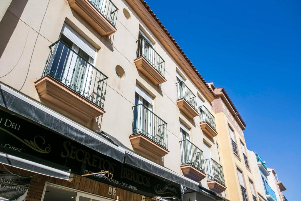 托雷莫利諾斯的住宿－Apartamentos Vicenta Playa Carihuela，旁边带阳台的建筑