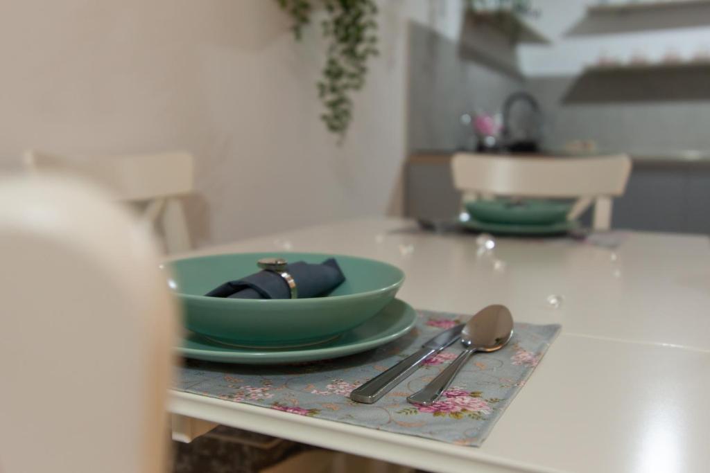 a table with a green bowl and spoons on it at MM Apartments Zore in Zagreb