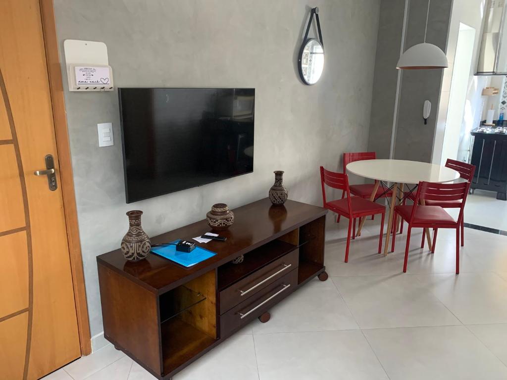 sala de estar con TV, mesa y sillas en Apto 2o andar novo 2 dorm - próximo ao centro, en Poços de Caldas