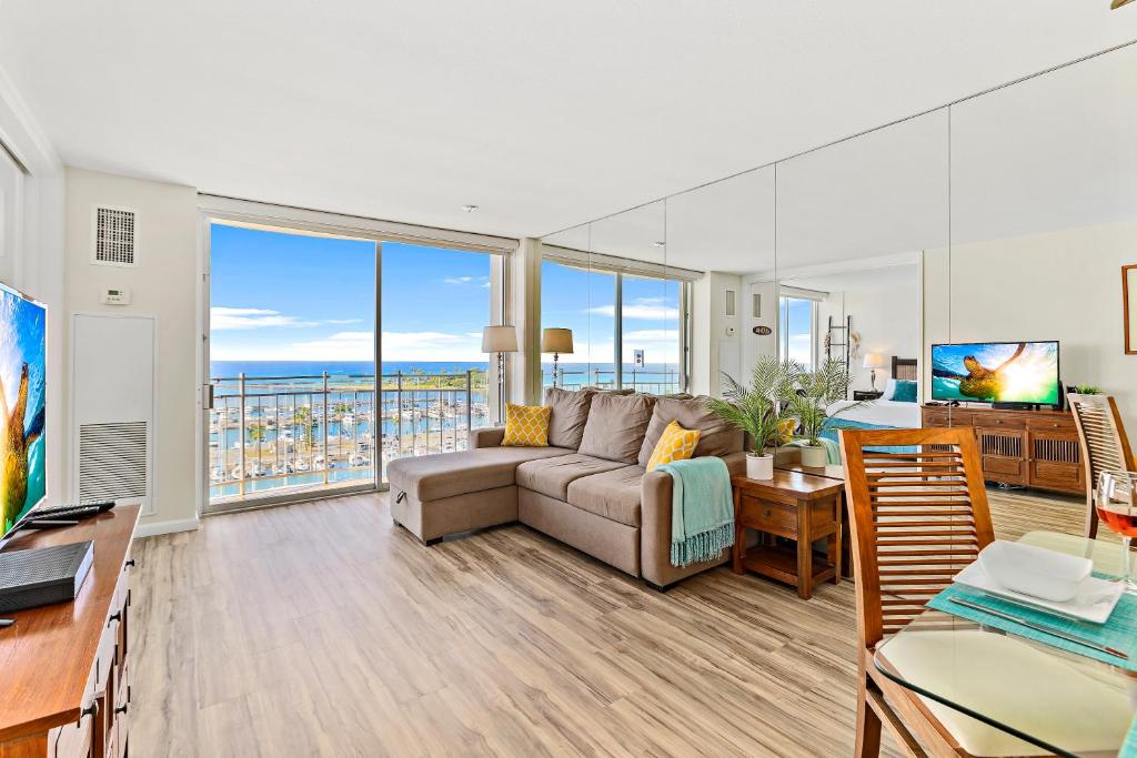 a living room with a couch and a view of the ocean at Stunning 1BR Ocean View Condo at Ilikai Marina in Honolulu