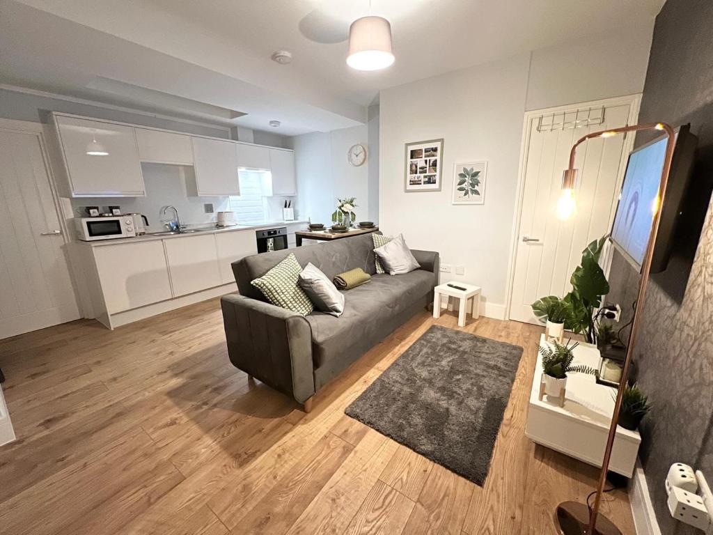 a living room with a couch and a kitchen at Homes from home by Tulloch Properties in Maidstone