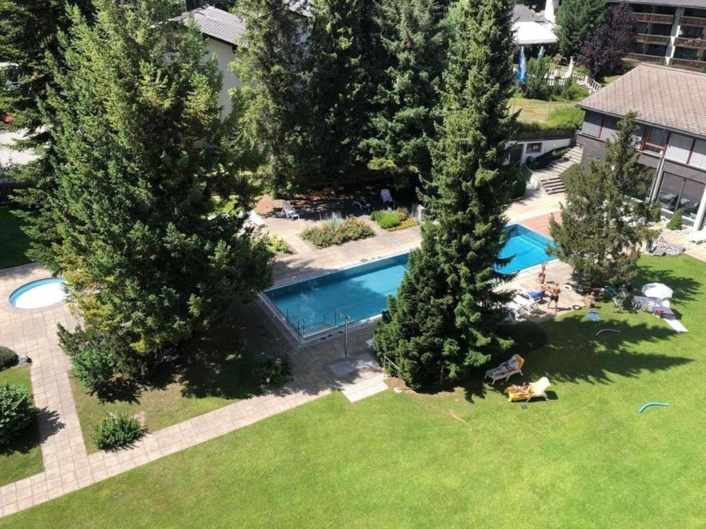 uma vista superior de uma piscina num quintal com árvores em Laax 1 12 Zi Whg mit Hallenbad, Aussen- Pool, Tennisplatz und Sauna em Laax