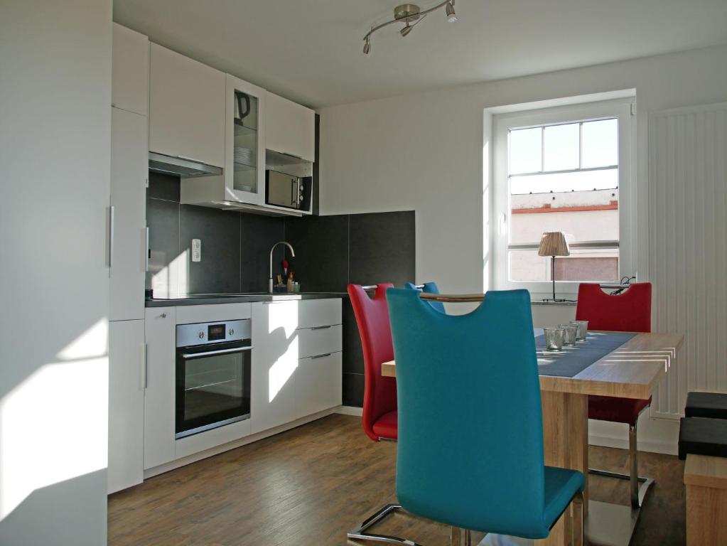 a kitchen with a table and a blue chair at Pferdestall in Grömitz