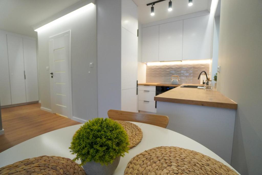 cocina con mesa, sillas y fregadero en Apartament Manhattan, en Płock