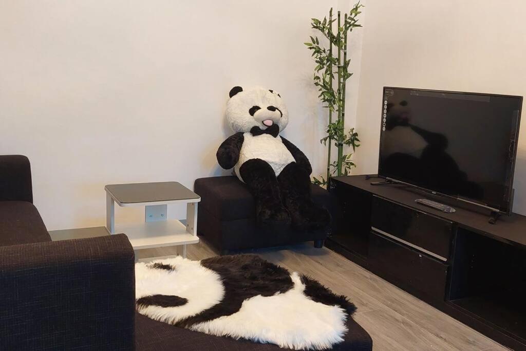 a stuffed panda bear sitting on a chair in a living room at Logan's Transient Home - U2 Apartment with Balcony in Baguio