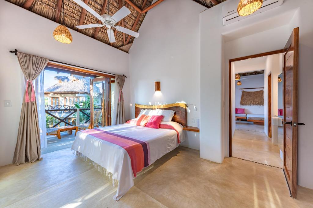 a bedroom with a bed and a large window at Casa Kuaa in Brisas de Zicatela