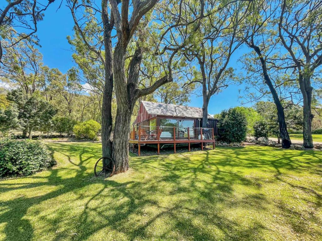 a house in the middle of a field with trees at Two Doors in Broke