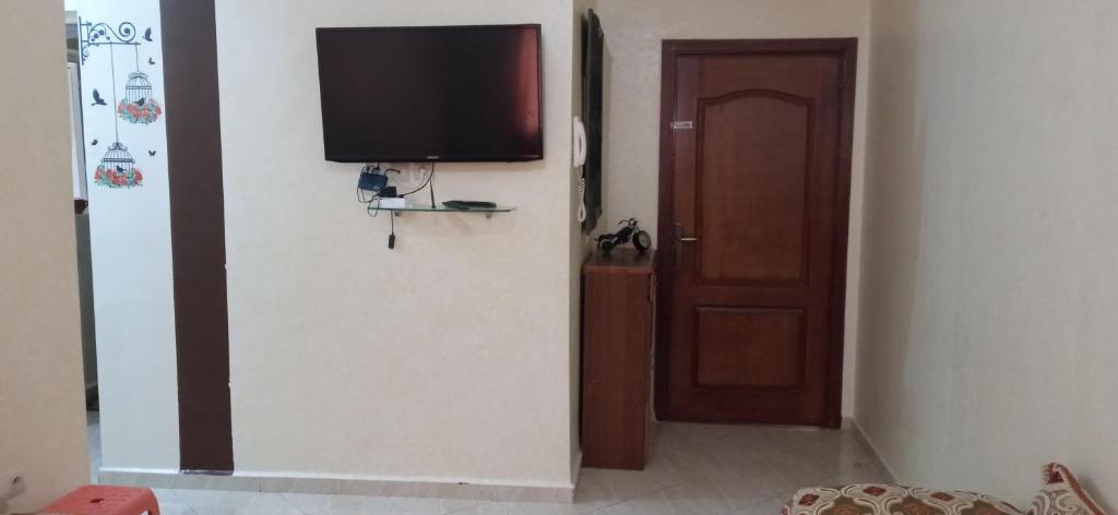 Zimmer mit einer Tür und einem TV an der Wand in der Unterkunft Darna in Agadir