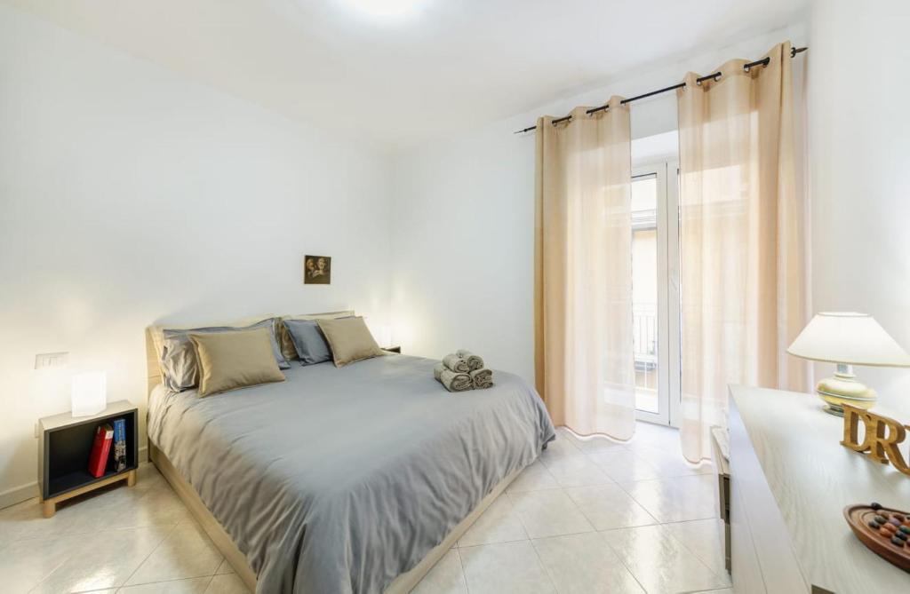 Habitación blanca con cama y ventana en casa Klaire Pozzuoli, en Pozzuoli
