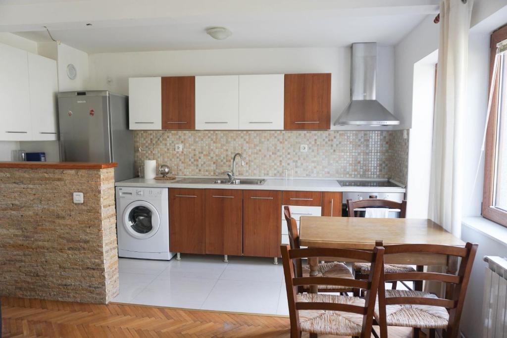 a kitchen with a table and a sink and a dishwasher at Studio K2 in Skopje