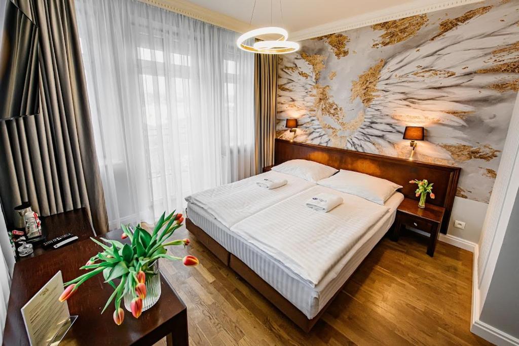 een slaapkamer met een bed en een groot schilderij aan de muur bij Villa Neve in Ustrzyki Dolne