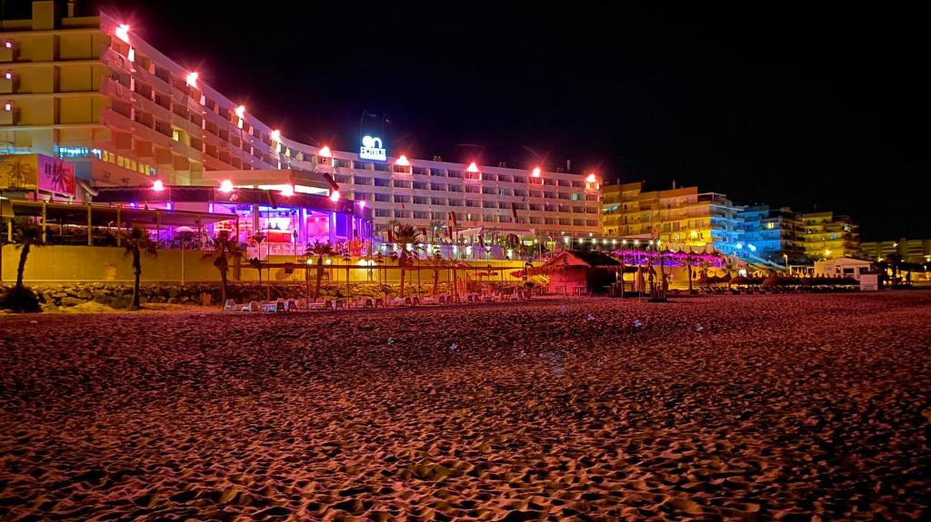 a beach at night with buildings and lights at Paraíso! in Matalascañas