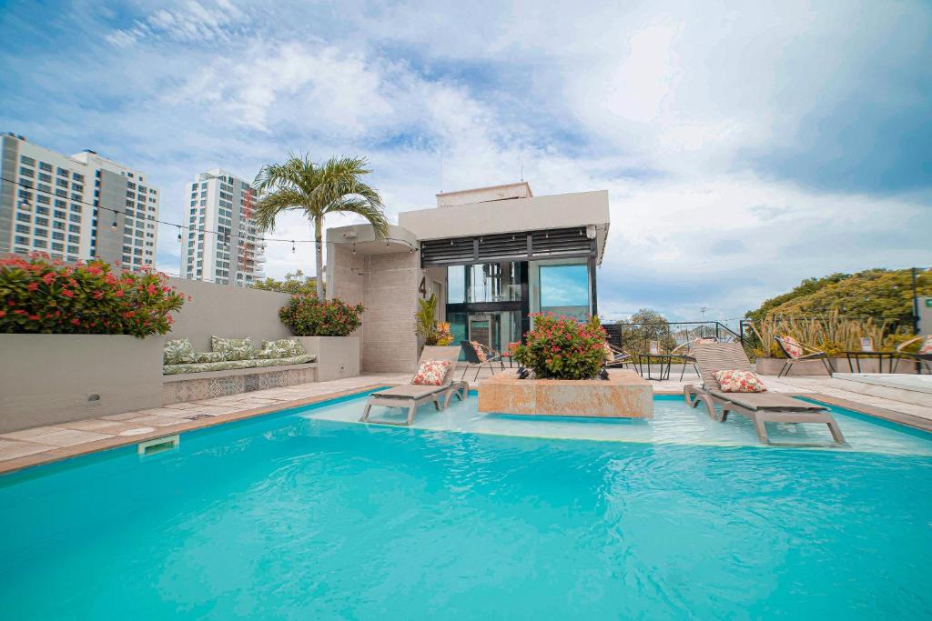 a swimming pool with chairs and a house at Alko Hotel Cotona in Santa Marta