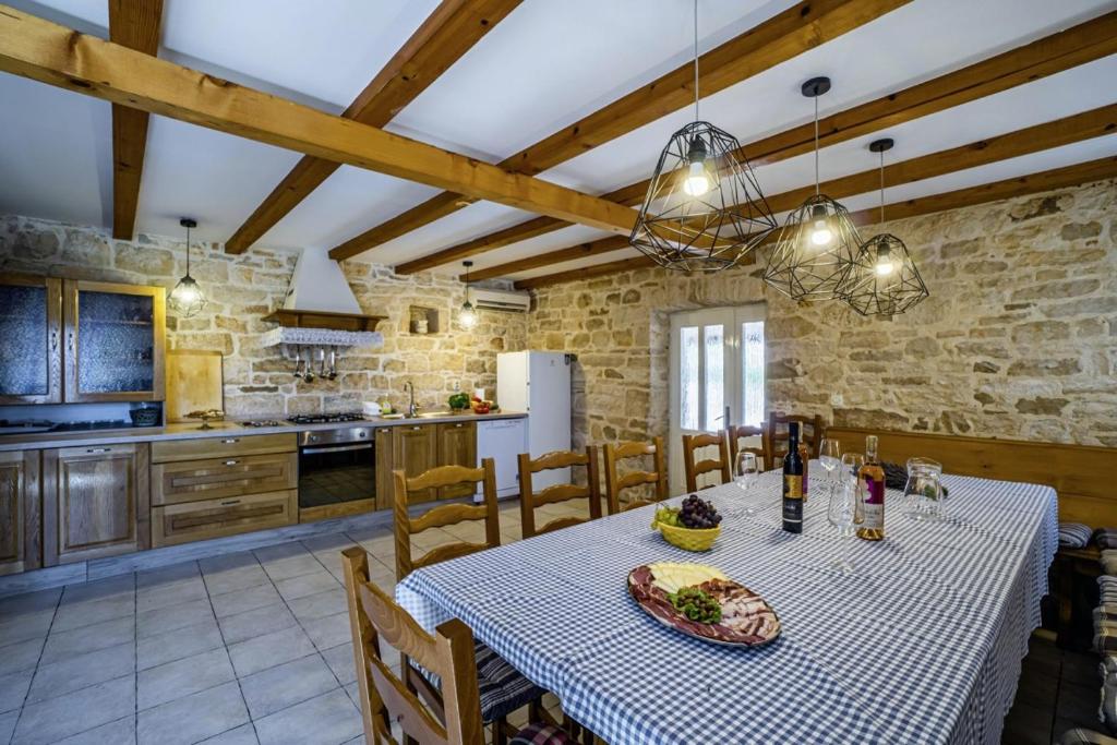 kuchnia i jadalnia ze stołem i krzesłami w obiekcie Kutić in Štokovci (Haus für 10-15 Personen) w mieście Svetvinčenat