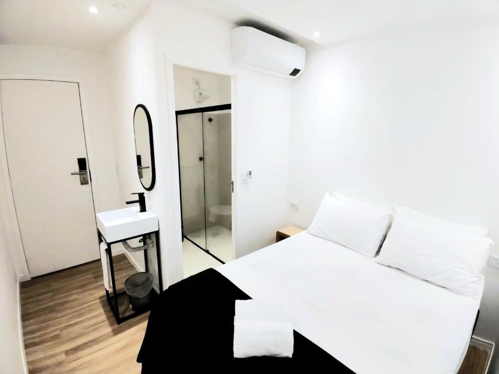 a bedroom with a white bed and a mirror at Sao Paulo Hostel Club in São Paulo