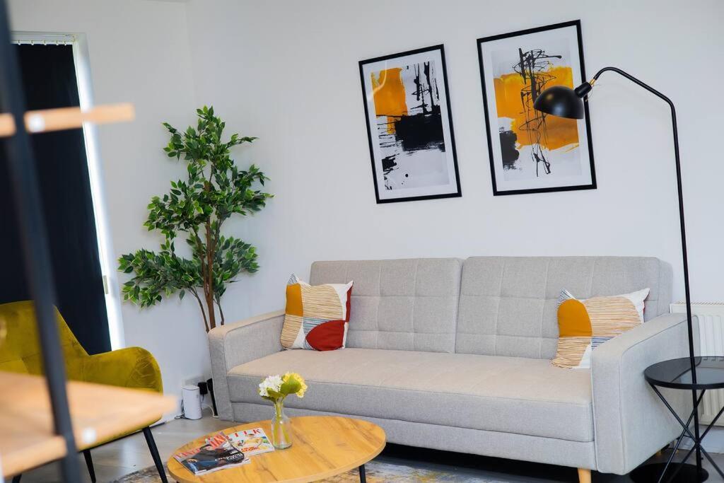 uma sala de estar com um sofá e uma mesa em Isinmi Home - Close to MCR City em Manchester