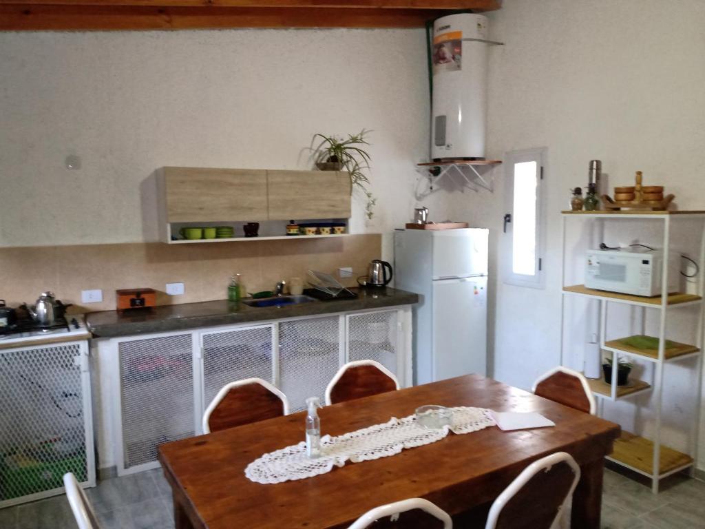 cocina con mesa de madera con sillas y nevera en Villa- Alba en Carpintería