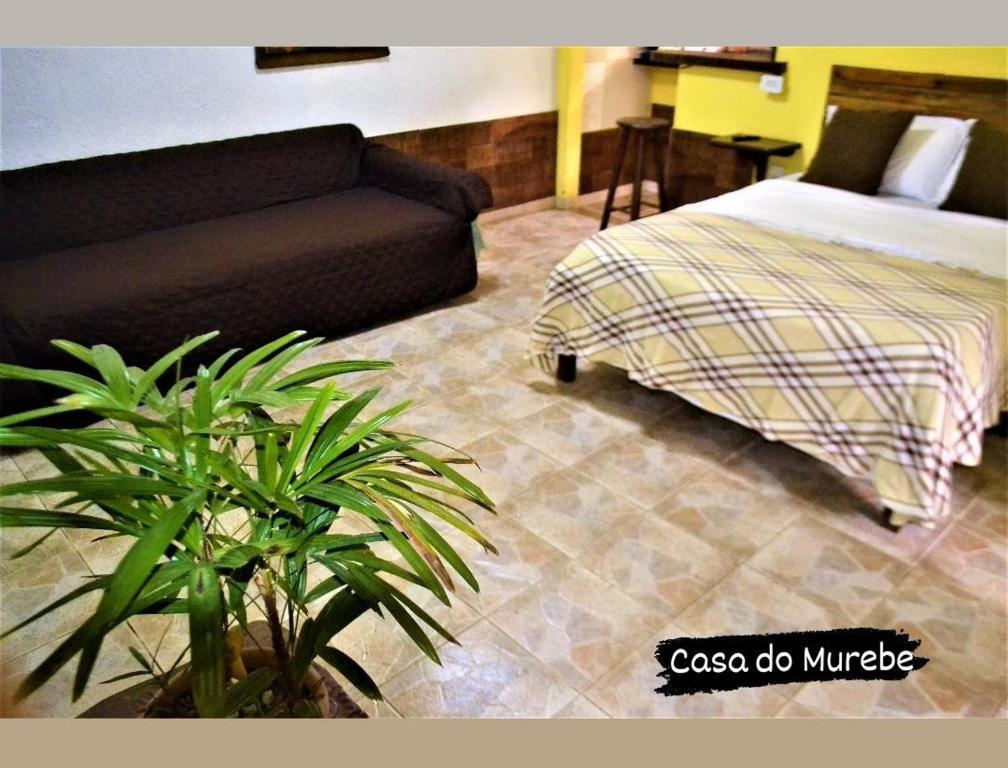 a living room with a bed and a couch at Casa do Murebe in Búzios