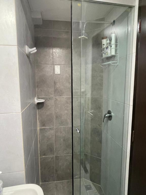 y baño con ducha y puerta de cristal. en Estudio acogedor y elegante, en Cochabamba