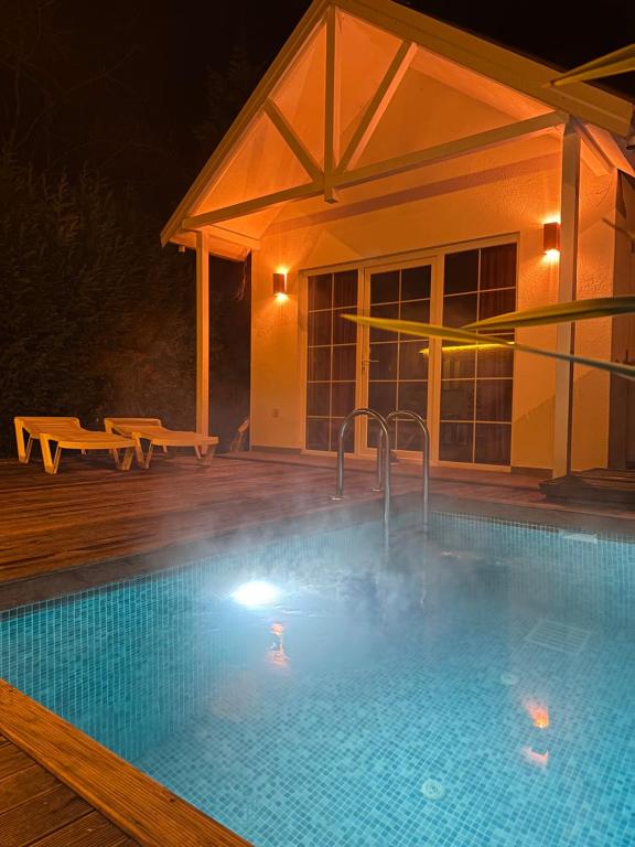a heated swimming pool at night with a house at Latte Villas in Sapanca