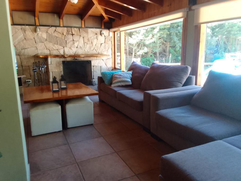 sala de estar con sofá y chimenea en Casa Curapil en San Carlos de Bariloche