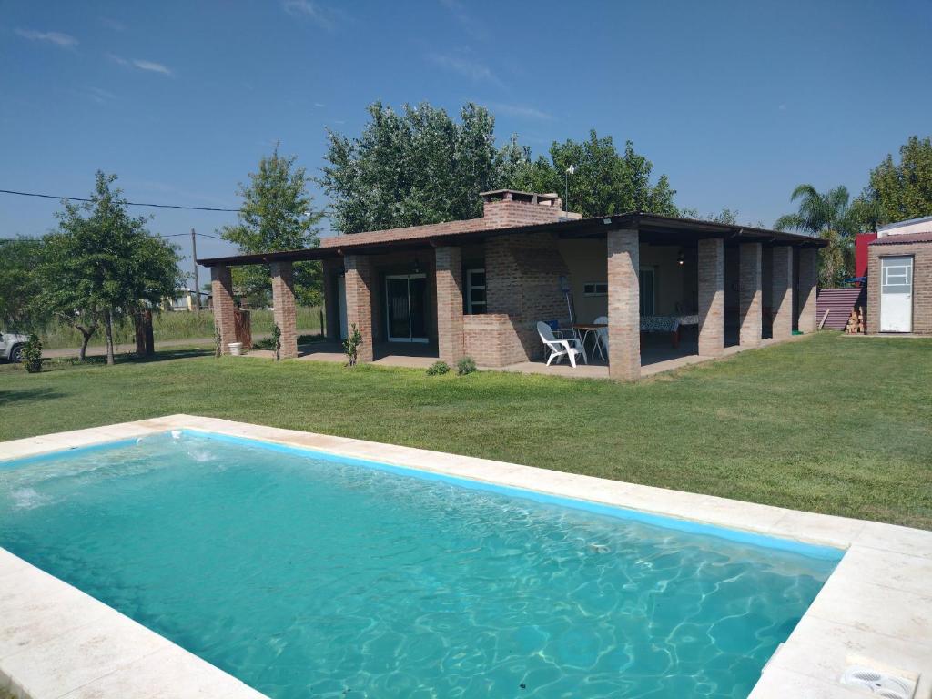 uma grande piscina em frente a uma casa em Casa de campo Los Cardenales em Rafaela