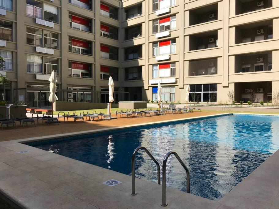 a swimming pool in front of a large building at Apartamento céntrico in Montevideo