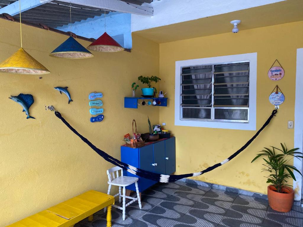 una habitación con una pared amarilla con una cuerda en Cantinho MurchioBom en Peruíbe