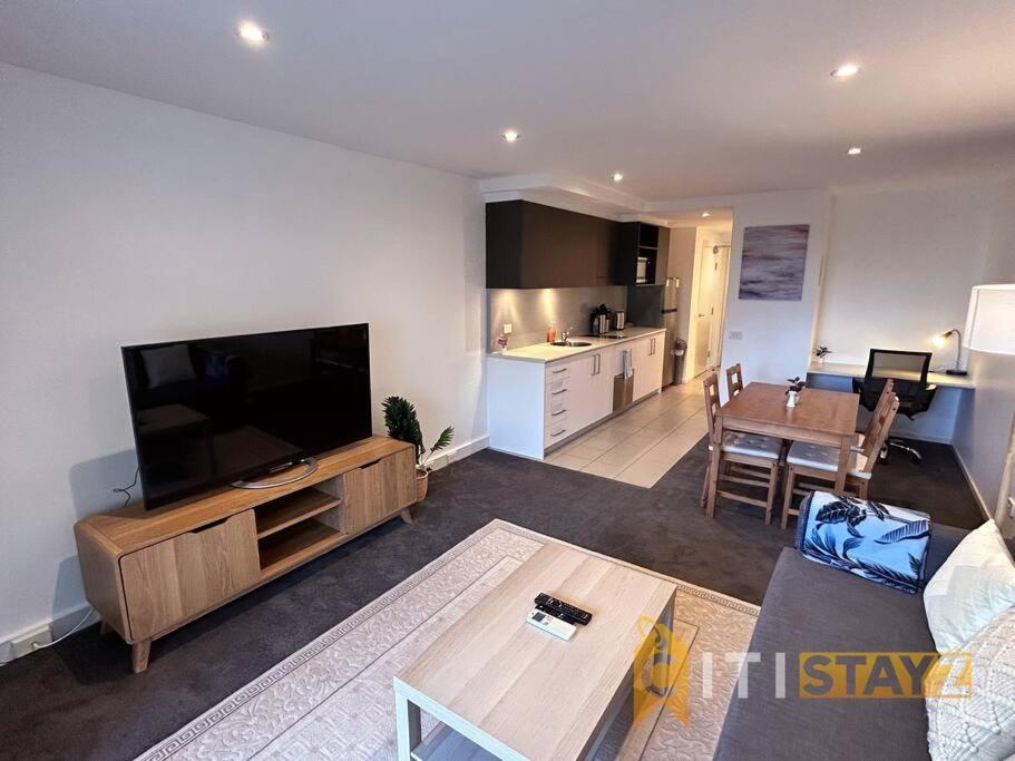 sala de estar con TV de pantalla plana y cocina en Relaxing Oasis in Bruce -1bd 1bth 1 carsp Apt, en Belconnen