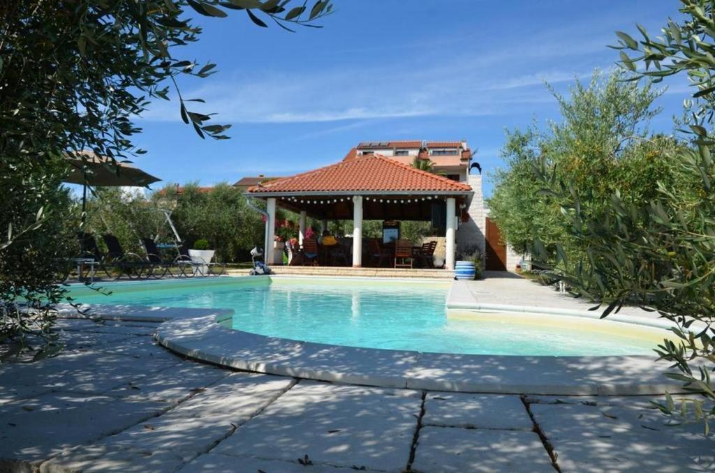 een zwembad met een tuinhuisje in de tuin bij Family friendly apartments with a swimming pool Povljana, Pag - 244 in Povljana