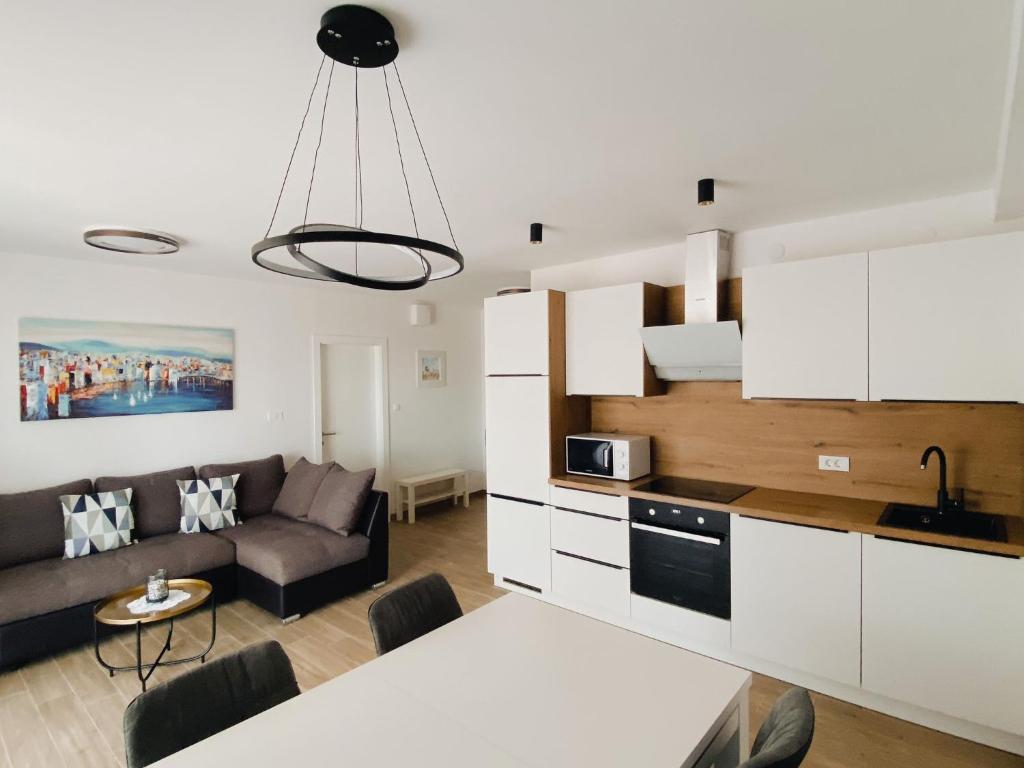 kuchnia i salon z kanapą i stołem w obiekcie Family friendly apartments with a swimming pool Povljana, Pag - 244 w mieście Povljana