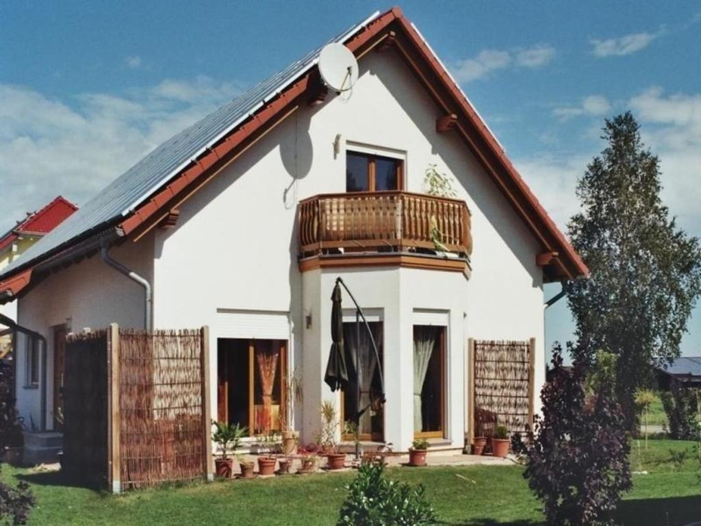 Cette maison blanche dispose d'un balcon. dans l'établissement Ferienwohnung für Nichtraucher am Ortsrand mit Balkon, 4 Sterne DTV Klassifizierung, à Bad Buchau
