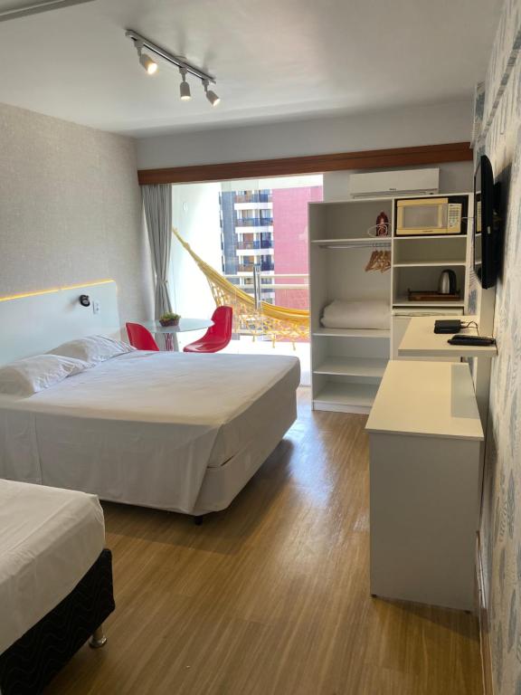 a hotel room with two beds and a desk at Garvey Park Hotel in Brasilia