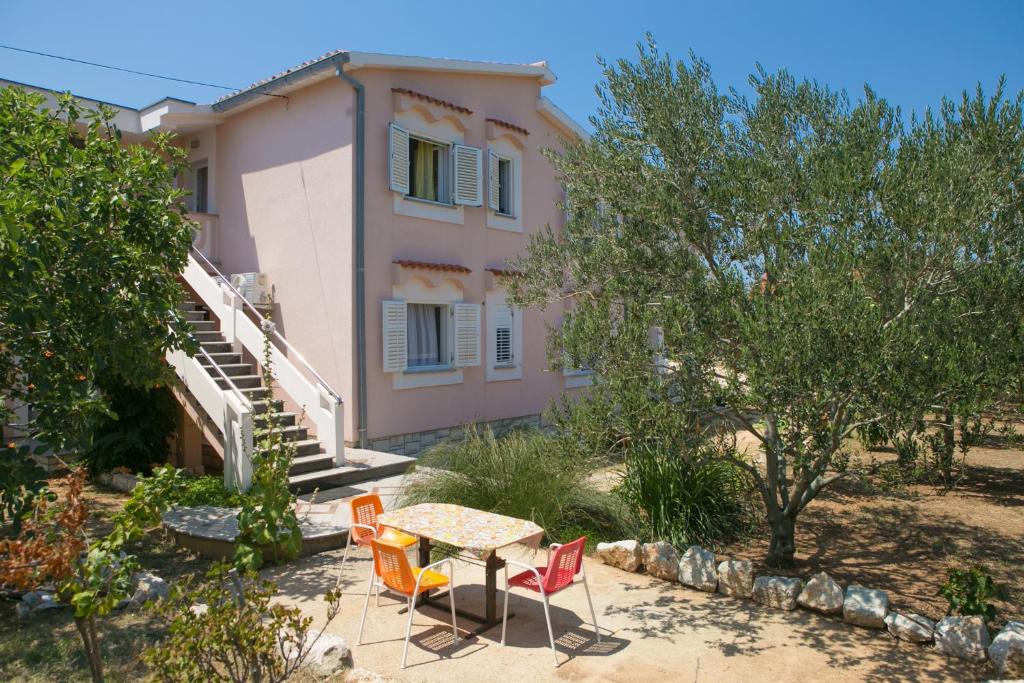 a table and chairs in front of a house at Apartments for families with children Novalja, Pag - 6490 in Novalja