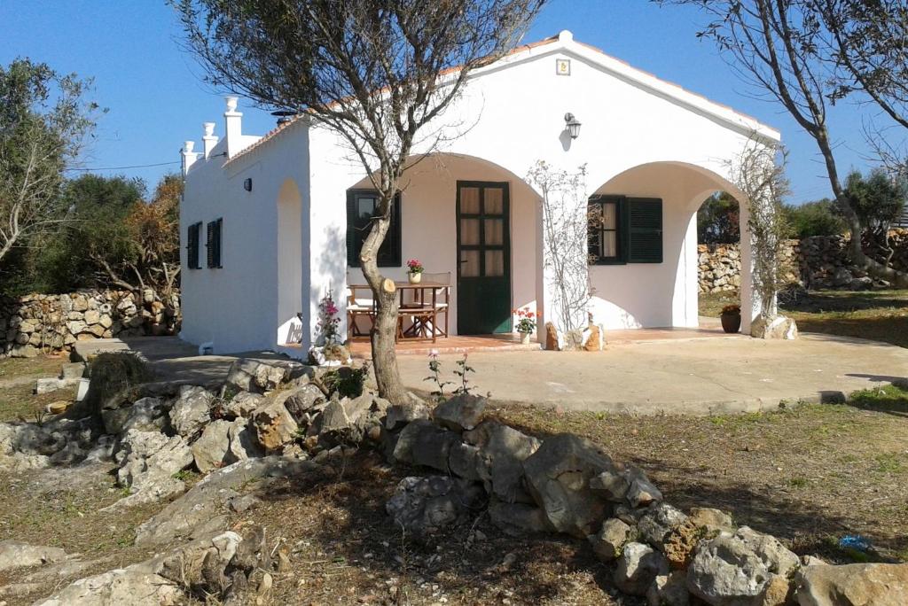 a small white house with a tree in front of it at Vinya Alice in Ciutadella