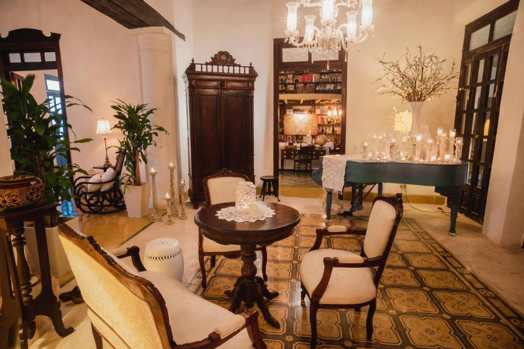 Los Murmullos Casa Boutique por chef Patrick Cros, Campeche في كامبيش: غرفة معيشة مع طاولة وبيانو
