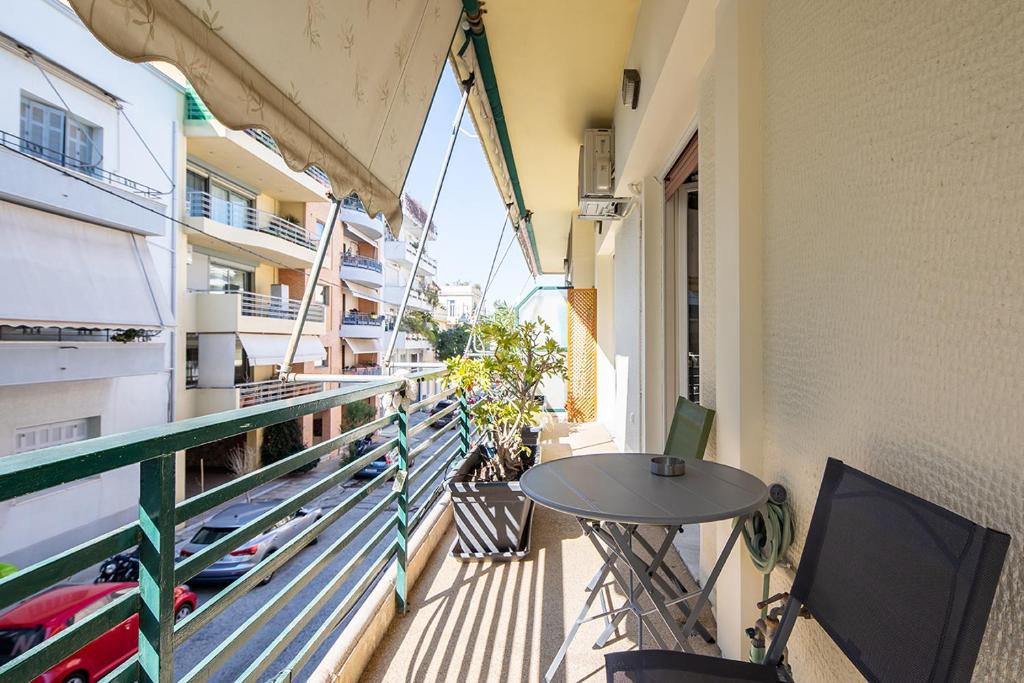 balkon ze stołem i krzesłami na budynku w obiekcie Olympic Mets Apartment w Atenach