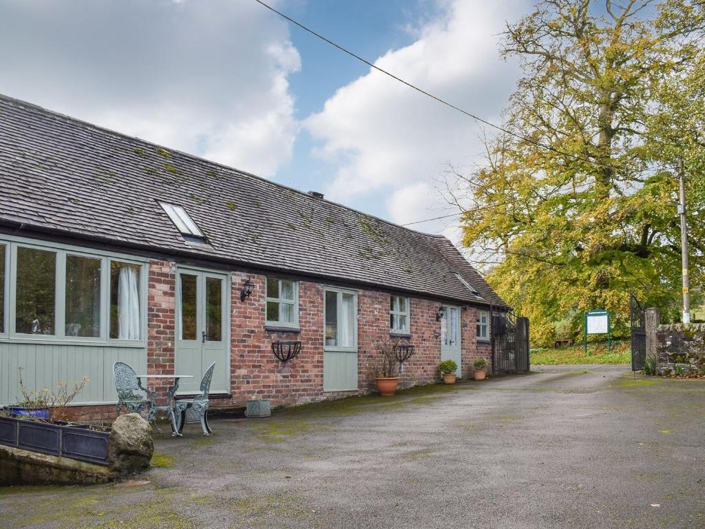 a brick house with a table and chairs in front of it at Swallows - Uk41742 in Mayfield