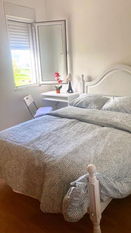 a bedroom with a white bed and a window at Lisbon Airport Guesthouse in Lisbon