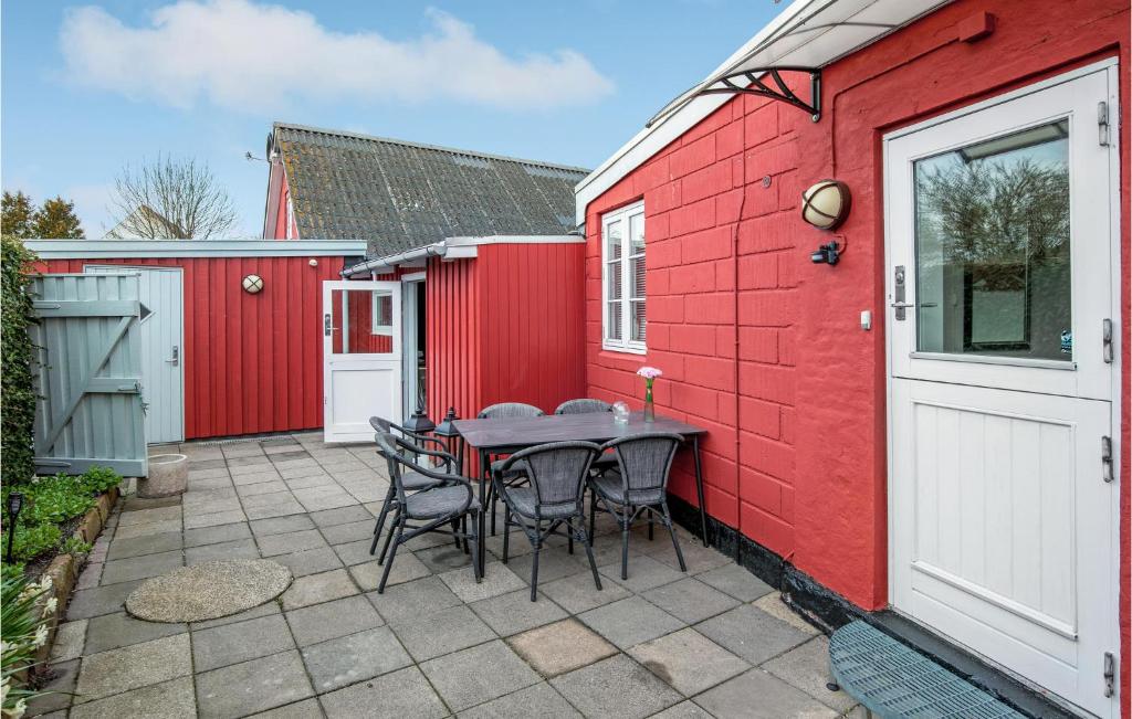 un patio con mesa y sillas junto a un edificio rojo en Lovely Apartment In Nex With Wifi, en Neksø