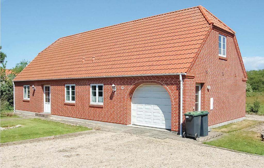 a red brick building with a white garage at Holiday Home Vadgårdsvej in Nørre Nebel