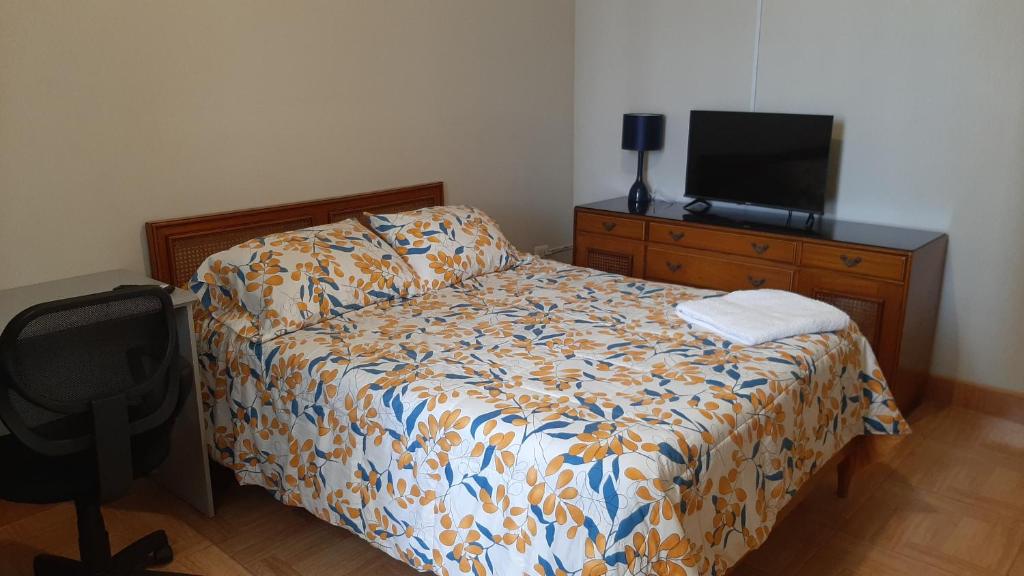 1 dormitorio con cama y vestidor con TV en Hospedaje Kelita en Moquegua